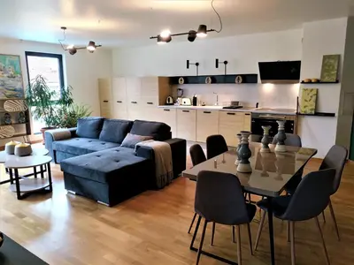 a living room with a blue couch and a table at Baratero Club Apartments Private Parking EV points in Sofia