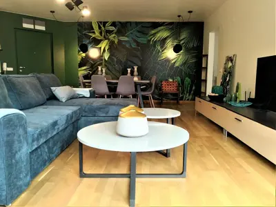 a living room with a blue couch and a table at Baratero Club Apartments Private Parking EV points in Sofia