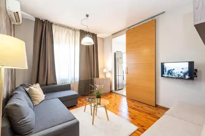 a living room with a couch and a tv at Rentapart Step in Sofia