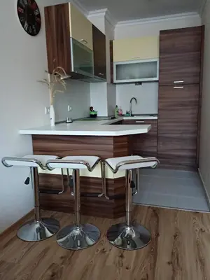 a kitchen with a counter and two bar stools at Denitsa Apartment in Borovets