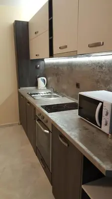 a kitchen with a stove and a microwave at Ayberk Apart Sandanski in Sandanski