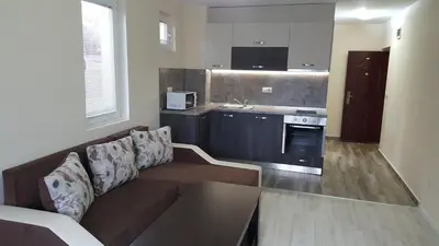 a living room with a couch and a kitchen at Ayberk Apart Sandanski in Sandanski