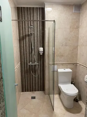 a bathroom with a toilet and a glass shower at Hotel Forum in Pazardzhik