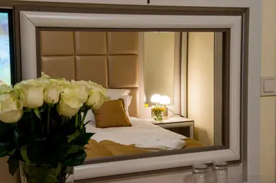 a mirror reflecting a bedroom with a bed in it at Hotel Forum in Pazardzhik
