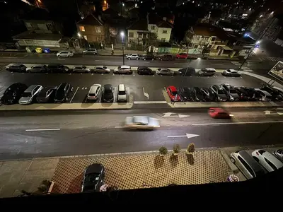 a view of a parking lot at night with cars parked at Hotel Forum in Pazardzhik