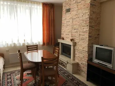 a living room with a table and a fireplace at Manastira 2 apt Emo Pamporovo in Pamporovo