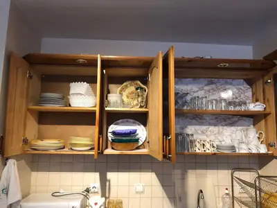 a kitchen with wooden cabinets with plates and dishes at Manastira 2 apt Emo Pamporovo in Pamporovo