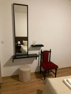 a mirror on a wall with a chair and a stool at Iglika 2 Ski Apartment in Borovets