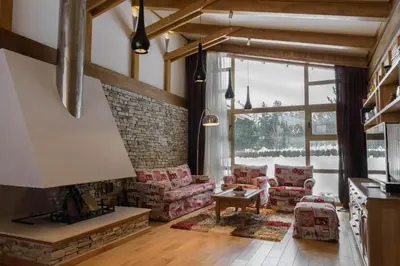 a living room with a fireplace and a brick wall at Villa Nataly at Golf Resort in Bansko