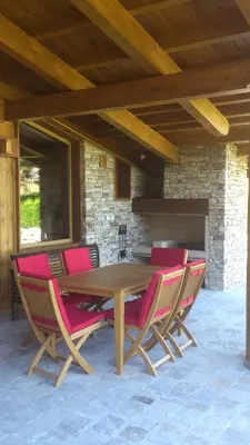 a wooden table with pink chairs and a stone fireplace at Villa Nataly at Golf Resort in Bansko