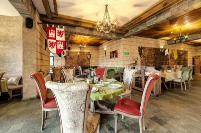 a dining room with tables and chairs and a chandelier at Royal Valentina Castle in Ognyanovo