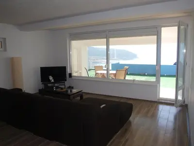 a living room with a large window with a view of the ocean at Lakeview-Estate ApartHotel in Staro Myasto