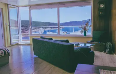 a living room with a couch and a large window at Lakeview-Estate ApartHotel in Staro Myasto
