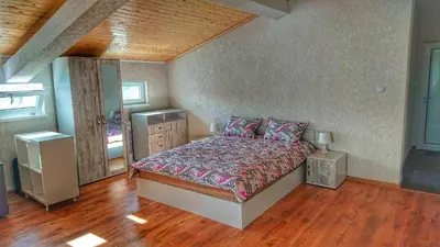 a bedroom with a bed and a wooden floor at Lakeview-Estate ApartHotel in Staro Myasto