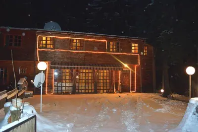 a building at night with snow in front of it at Persey Villa Borovets in Borovets
