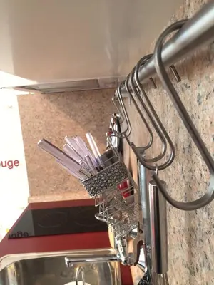 a dish drying rack next to a sink with utensils at Airport Apartment in Sofia