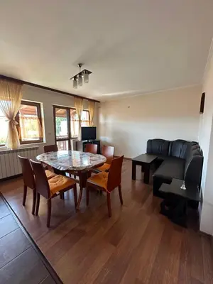 a living room with a table and chairs and a couch at Valevitsata Guesthouse in Razlog