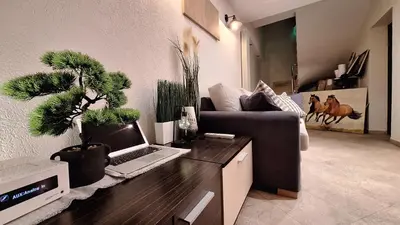 a living room with a couch and a laptop on a desk at Kadiyata Guest House in Bansko