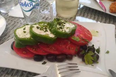a plate of food with vegetables and a fork at Kadiyata Guest House in Bansko