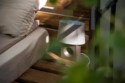 a lamp sitting next to a bed in a bedroom at Hot Spot Apartments in Sofia
