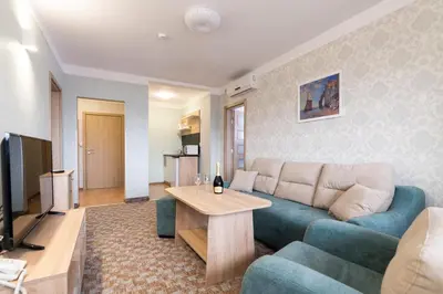 a living room with a couch and a table at Balneo & SPA Hotel Aura in Velingrad