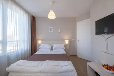 a hotel room with two beds and a flat screen tv at Blue Label Apart House in Sofia