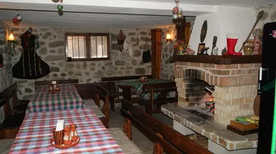 a restaurant with two tables and a brick fireplace at Guest House Garbevi in Dobrinishte