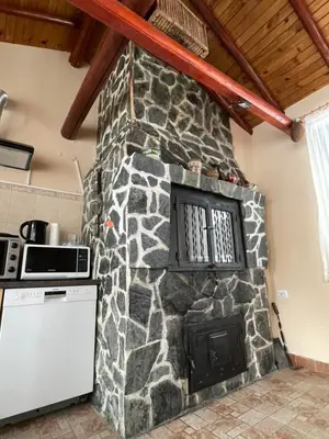a stone wall in a kitchen with a stove at Mama Emiliya Guest House in Beli Iskar
