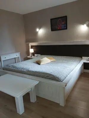 a bedroom with a large bed and a table at Galaxy Hotel in Chiflik