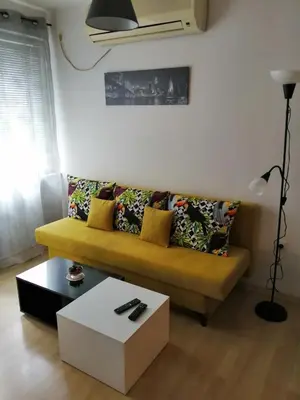 a living room with a yellow couch and a table at Apartment Lili in Blagoevgrad