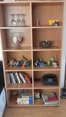 a wooden book shelf with toys and books at Central Park Studio in Plovdiv