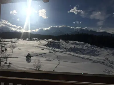 a snow covered field with the sun in the sky at PM Mountain View Fireside Retreat Bansko in Bansko