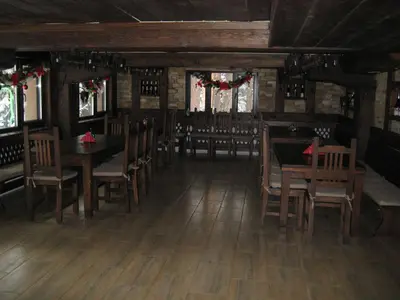 a dining room with wooden floors and tables and chairs at Hunting Residence Lodge in Panichishte