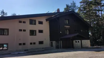 a large black and white building with a garage at Hunting Residence Lodge in Panichishte