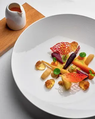 a white plate with food on a table at Zornitza Family Estate Relais & Chateaux in Melnik
