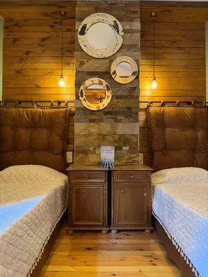 two beds in a room with wooden walls at Villa Adis with Hot Pool & Jacuzzi by BookVillaBG in Borovets