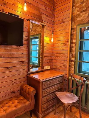 a room with a dresser and a tv and a chair at Villa Adis with Hot Pool & Jacuzzi by BookVillaBG in Borovets