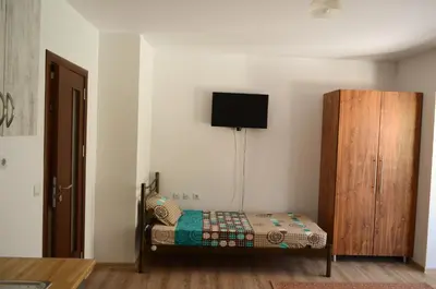 a bedroom with a bed and a wooden cabinet at Main Street Apartment in Sandanski