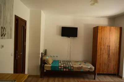 a bedroom with a bed and a wooden cabinet at Main Street Apartment in Sandanski