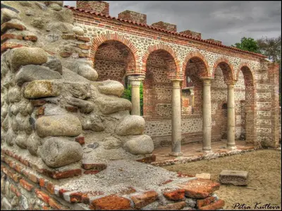 a brick building with arches and a pile of rocks at Main Street Apartment in Sandanski
