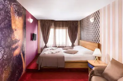 a bedroom with a large bed and a couch at Hotel Central Point in Sofia