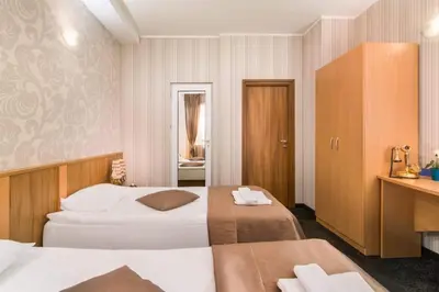 a hotel room with two beds and a desk at Hotel Central Point in Sofia