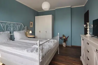 a bedroom with blue walls and a crib at Esterra Vini Guest House in Perushtitsa