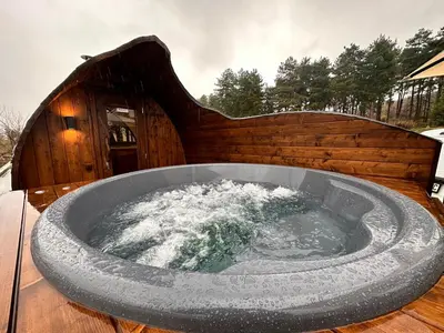 a large tub of water on a wooden deck at Esterra Vini Guest House in Perushtitsa