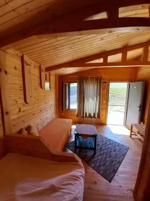a room with two beds in a log cabin at Вилно селище МИРОВЕЦ in Malŭk Izvor