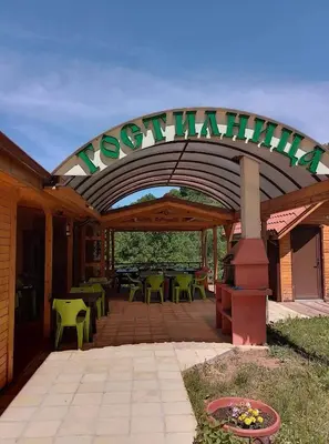 a covered patio with tables and chairs and a sign at Вилно селище МИРОВЕЦ in Malŭk Izvor