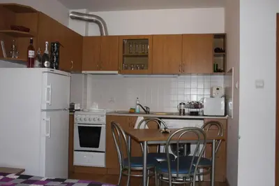 a kitchen with a table and chairs and a white refrigerator at Studio Moni in Pamporovo