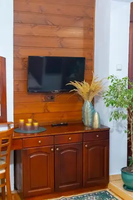 a wooden wall with a television on top of a wooden cabinet at Grancharova Guest House in Bansko