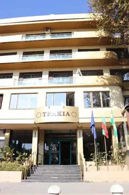 a hotel with flags in front of a building at Hotel Trakia in Pazardzhik