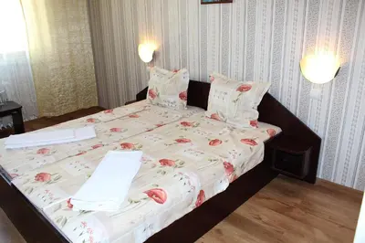 a large bed in a bedroom with a bedspread with tomatoes on it at Hotel Trakia in Pazardzhik